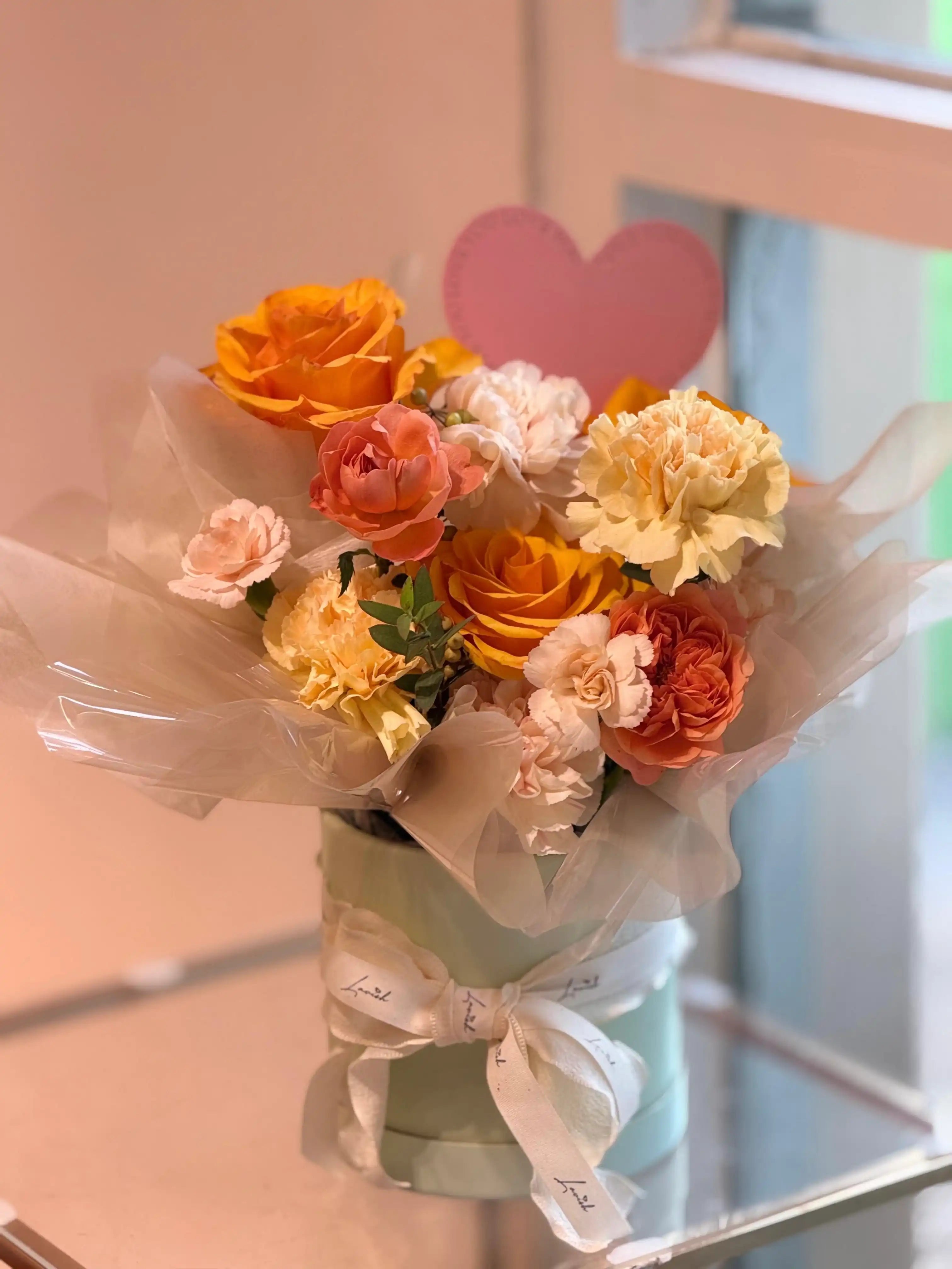 A warm, sunset-inspired floral gift box by Lavish Florist, showcasing premium amber roses and blush blooms for a cozy, sophisticated aesthetic.