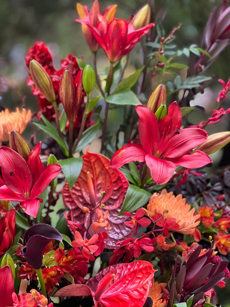 Ruby Noir grand opening flower stand close-up with red lilies, anthurium and dark calla lilies by Lavish Florist